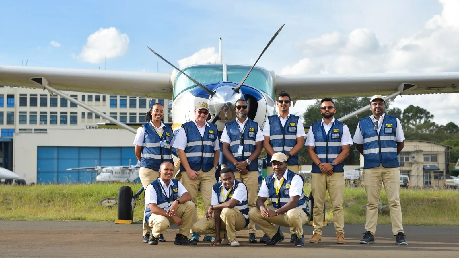 The Yellow Wings team in front of a Caravan at Wilson Airport, March 2026