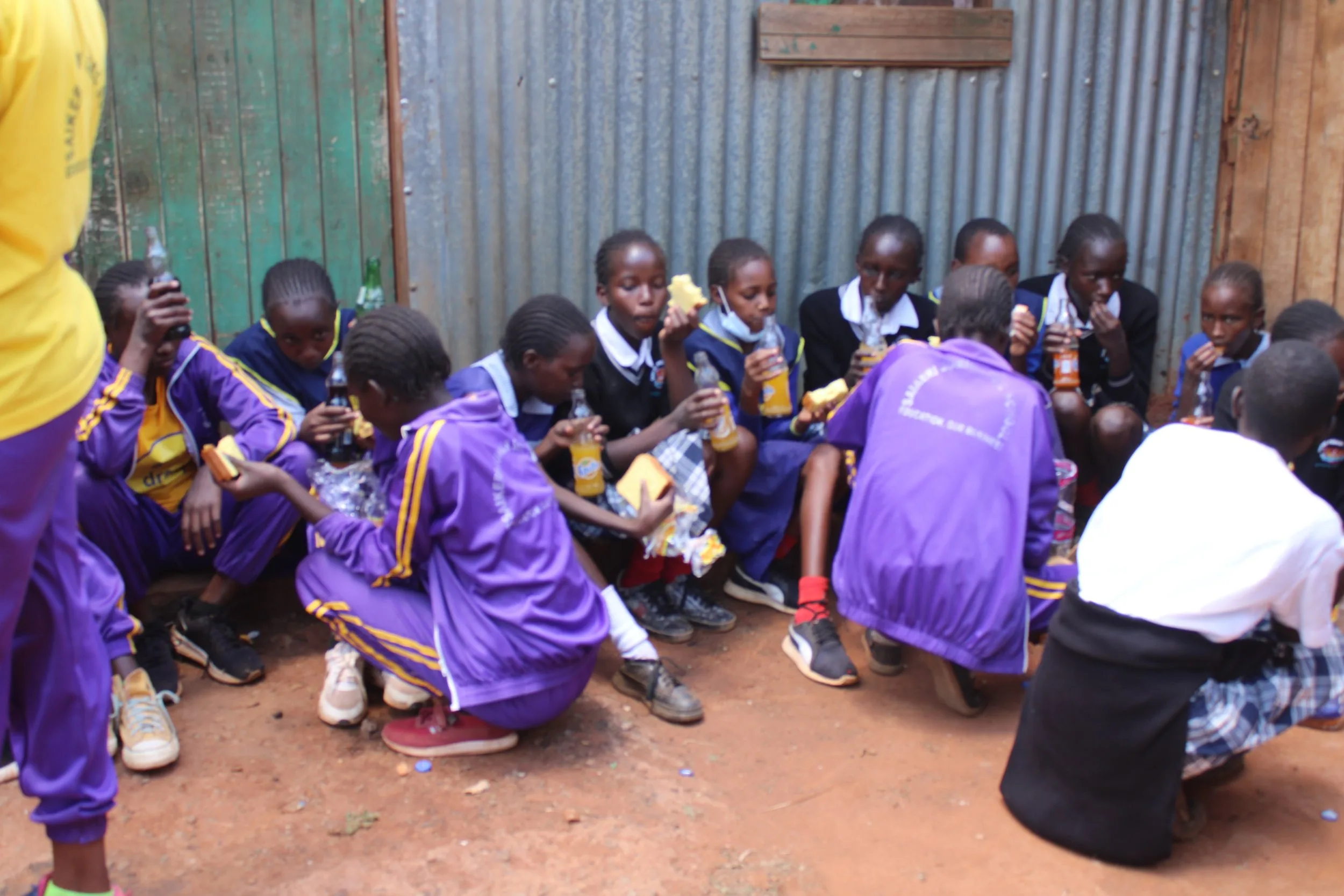Saikeri clean-up: pupils in purple tracksuits.