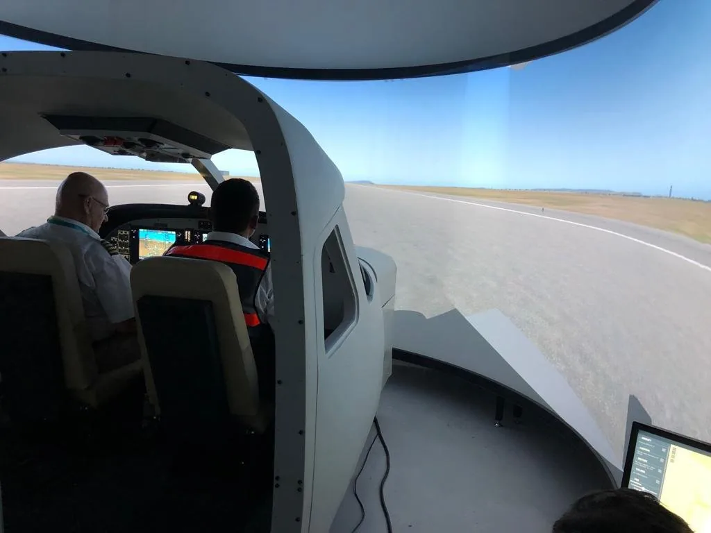 A Yellow Wings pilot and an instructor in a flight simulator.