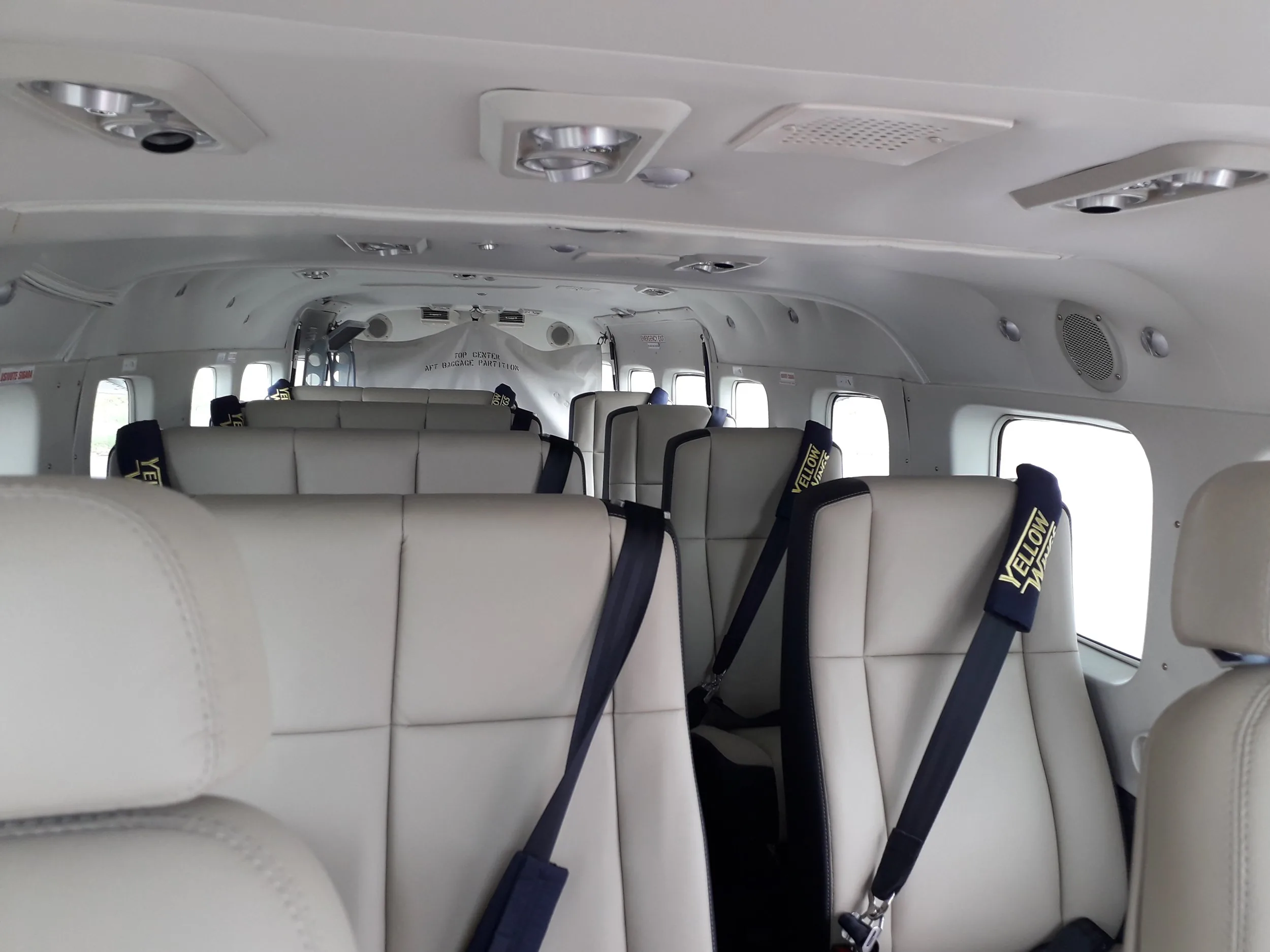 Inside a Yellow Wings Caravan: rows of single leather seats beside the windows