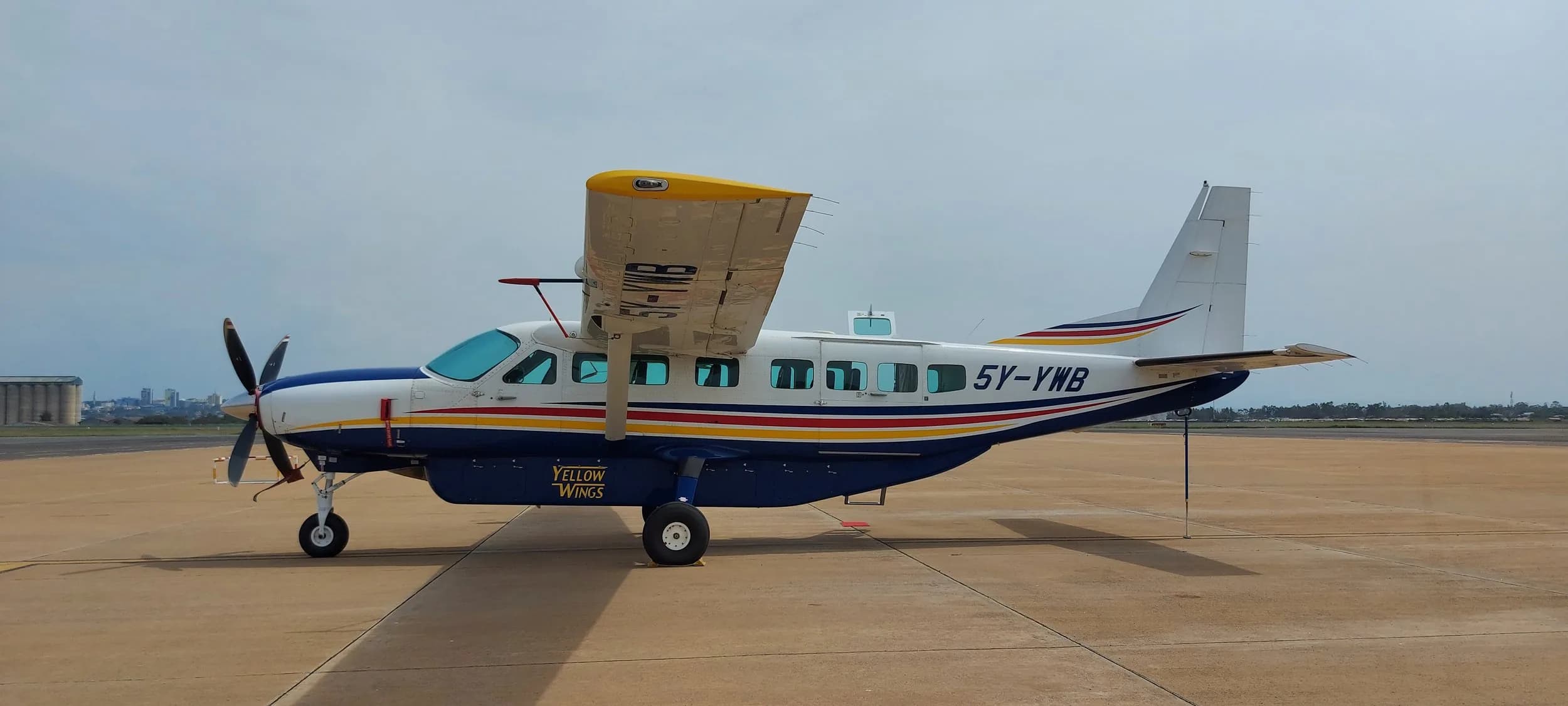 5Y-YWB in profile on a paved apron, wing flaps down