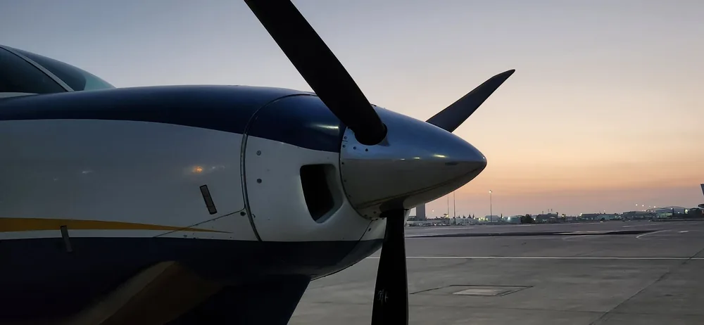 A Caravan's nose and propeller at sunset