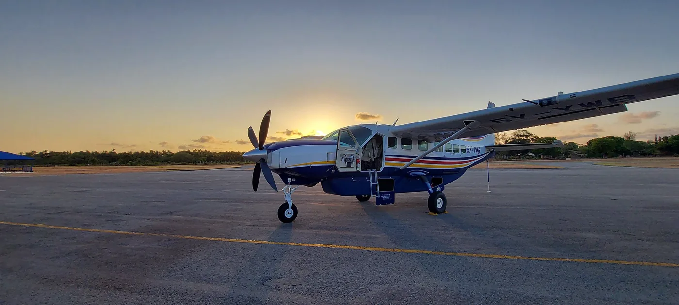 5Y-YWB at sunset on a coastal strip among palm trees