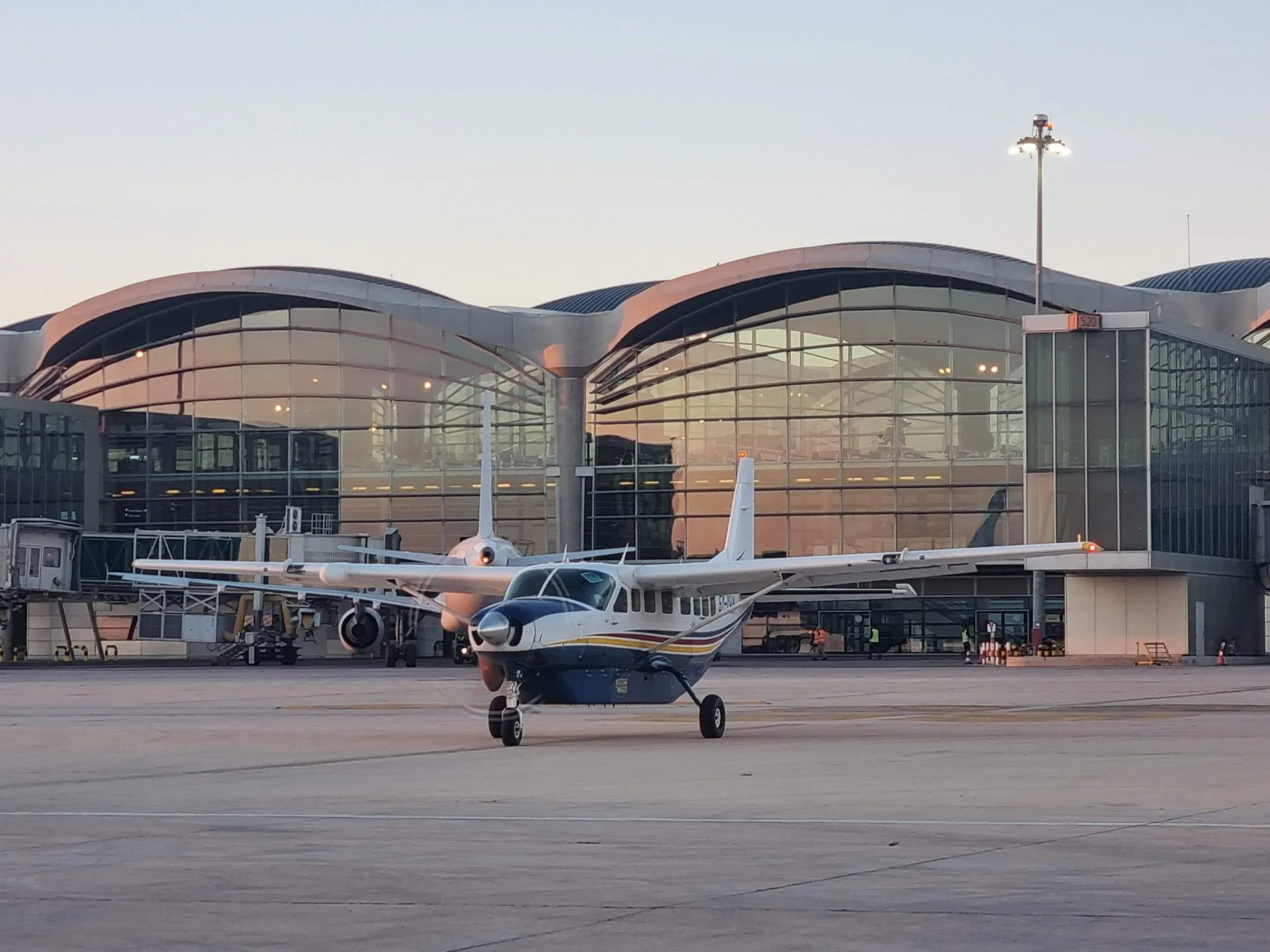 A Yellow Wings Caravan at a modern airport terminal