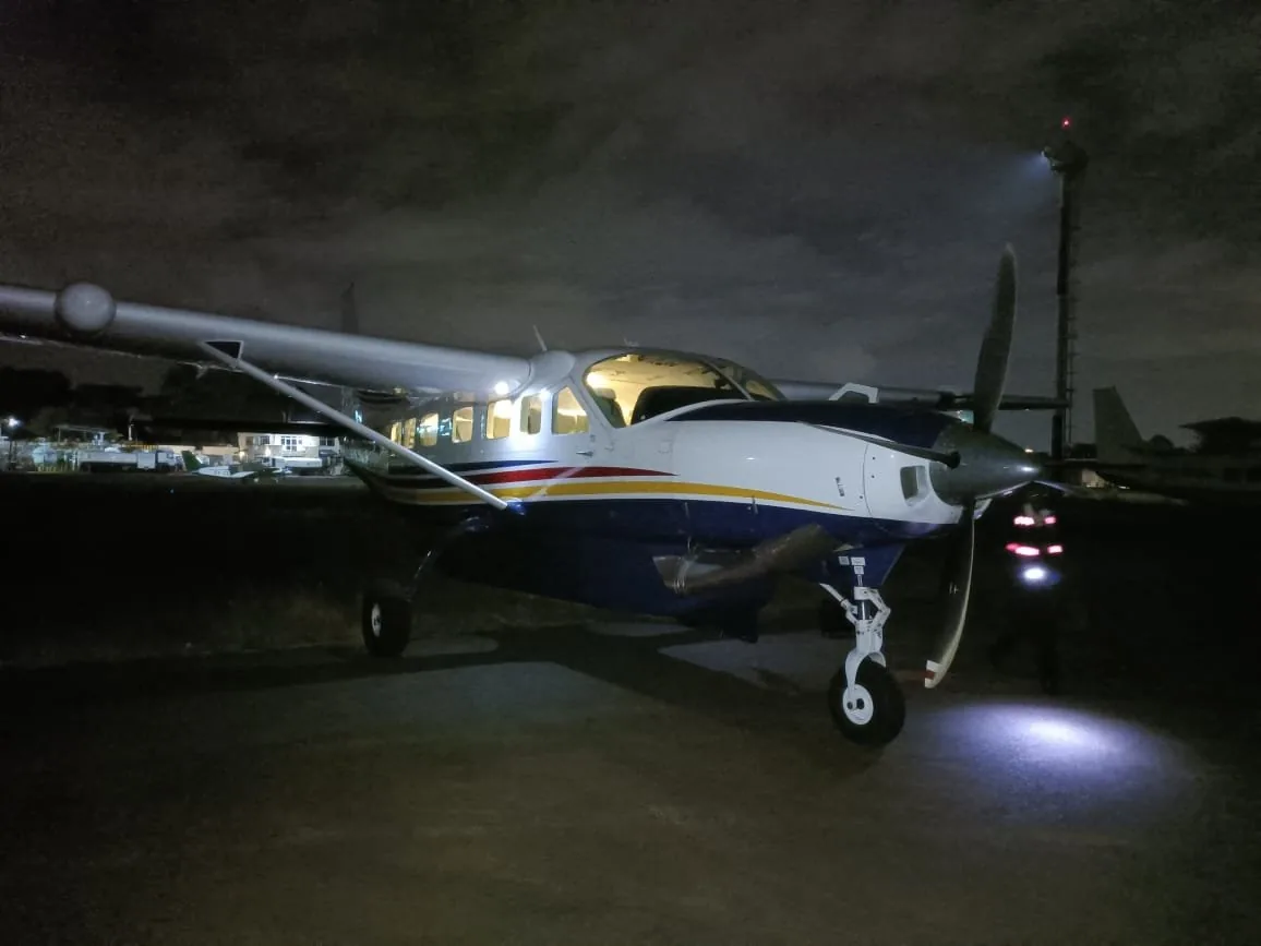 A Caravan on the apron at night, landing light on